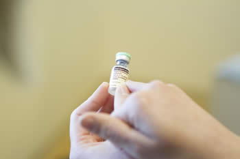 nurse pointing to vaccine label